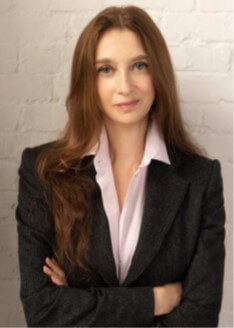a woman with brown hair wearing a suit