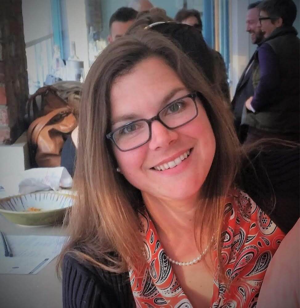 A woman with brown hair and glasses smiling